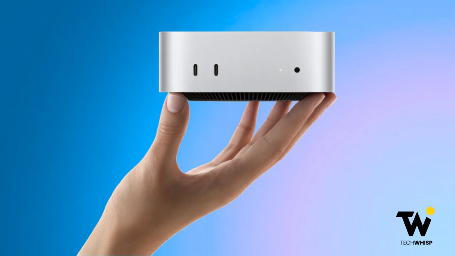 A person holding a compact silver Apple Mac Mini desktop computer in the palm of one hand against a blue gradient background.